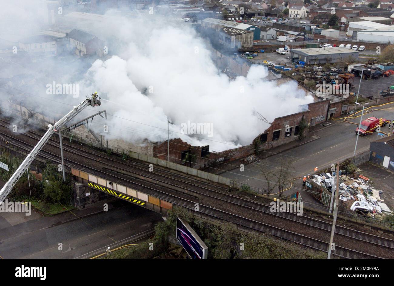 Feuerwehrleute am Tatort eines Großschadens in einer verlassenen Fabrik in Lower Horseley Fields, Wolverhampton, wo ein Brand mehrere Fabrikeinheiten erfasst hat, wobei mehr als 100 Feuerwehrleute anwesend waren, um den Brand abzufangen. Foto: Dienstag, 6. Dezember 2022. Stockfoto