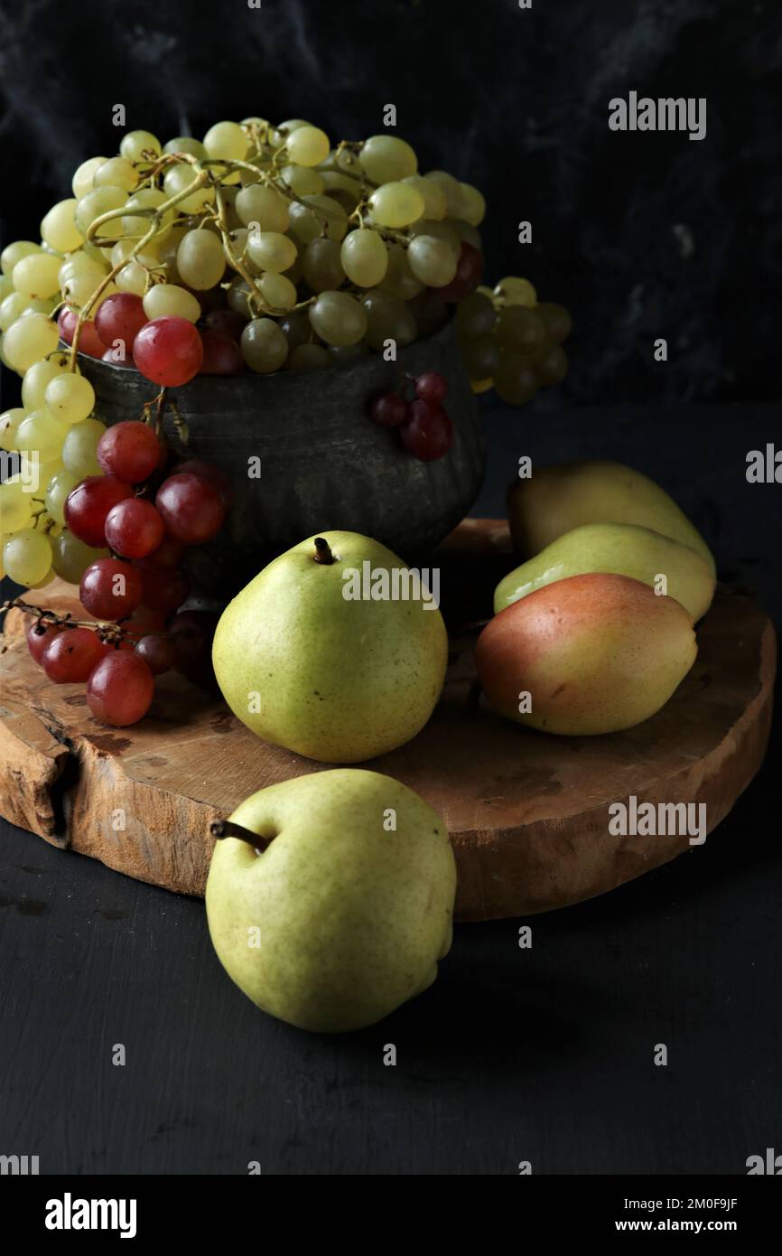 Trauben- und Birnenfrüchte auf schwarzem Hintergrund Stockfoto