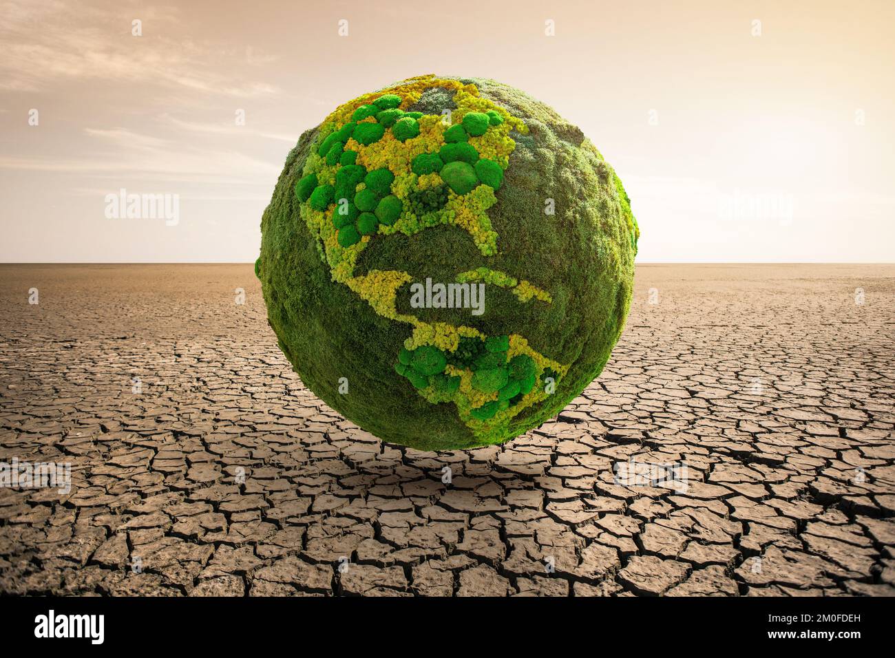 Grüner Planet Erde in der Wüste. Symbol der globalen Erwärmung und des Klimawandels Stockfoto