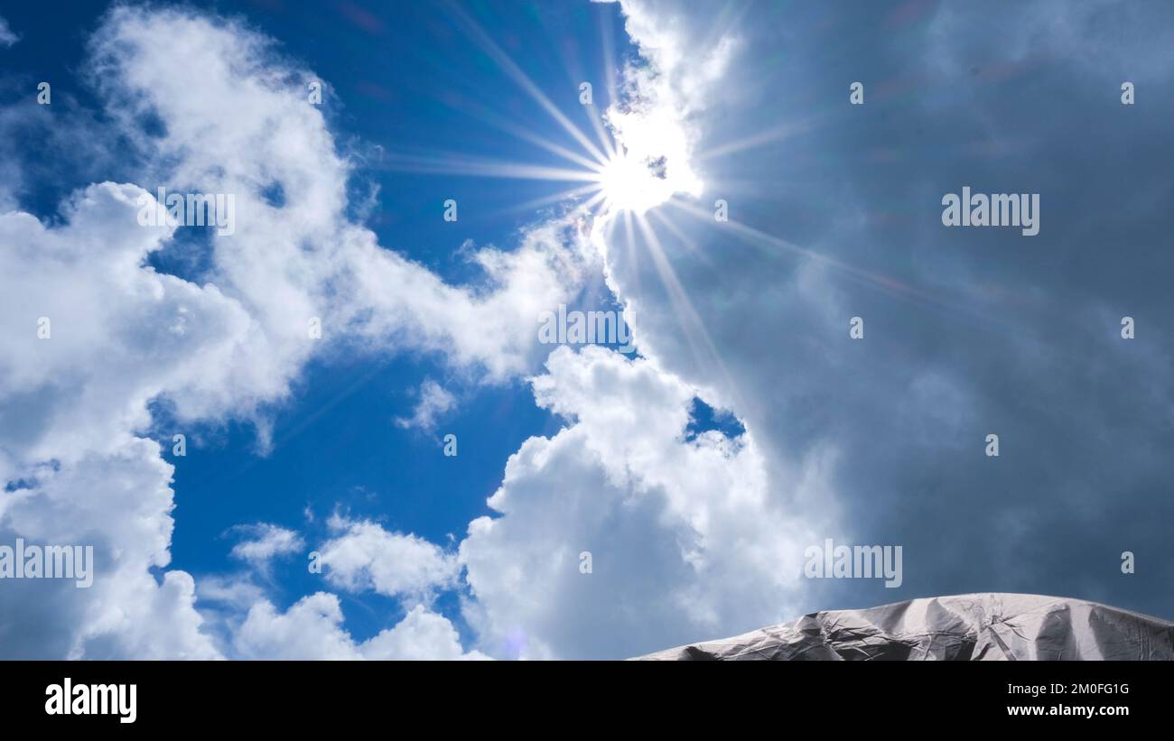 Luftaufnahme des wunderschönen Himmels mit Wolken und Sonne an einem Sommertag. Zeitraffer von Wolken über dem blauen Himmel mit der Sonne. Himmelslandschaft. Stockfoto