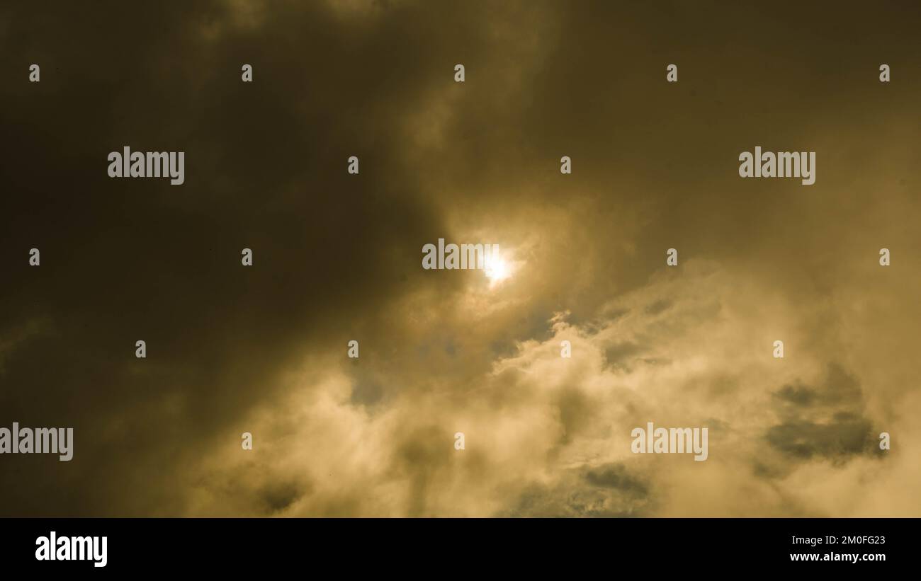 Zeitraffer goldener Wolken, die sich bei Sonnenuntergang durch den Himmel bewegen. der goldene Sonnenuntergang am Himmel im Naturhintergrund. Stockfoto