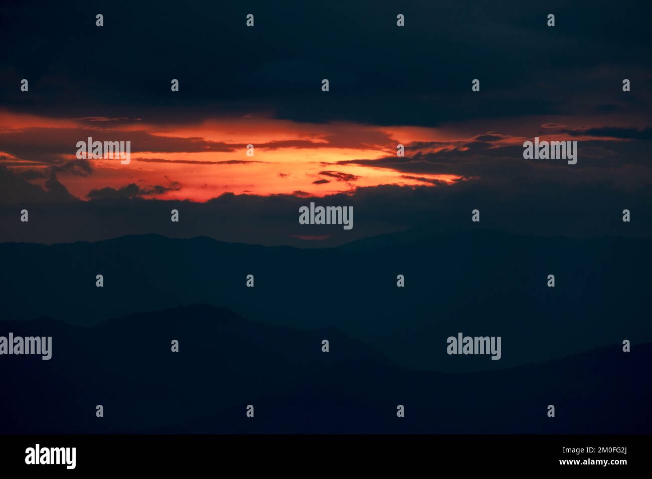 Zeitraffer der wunderschönen Sonnenuntergangslandschaft auf dem Gipfel des Berges. Aus der Vogelperspektive sehen Sie die wunderschönen Silhouetten des tropischen Tals mit den letzten Strahlen des Stockfoto