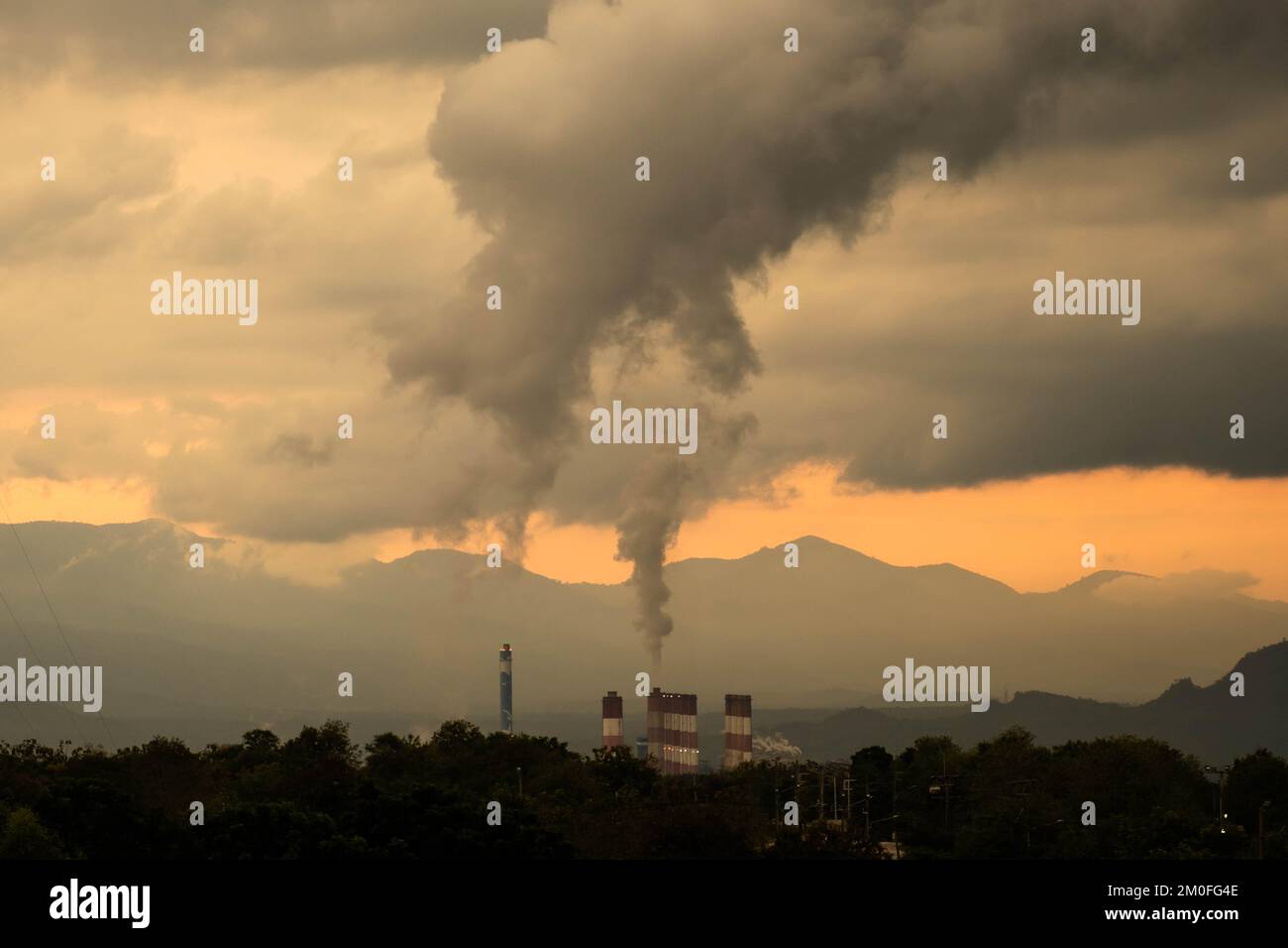 Zeitraffer eines Kohlekraftwerks und Dampf, der bei Sonnenuntergang aus den Stapeln strömt. Steinkohlekraftwerk bei Nacht aus der Vogelperspektive. Industrielandschaft Stockfoto