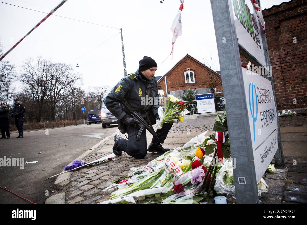 Am Tag nach den Schießereien in Krudttonden in Kopenhagen. Ein Polizist stellt Blumen auf Krudttonden. Stockfoto