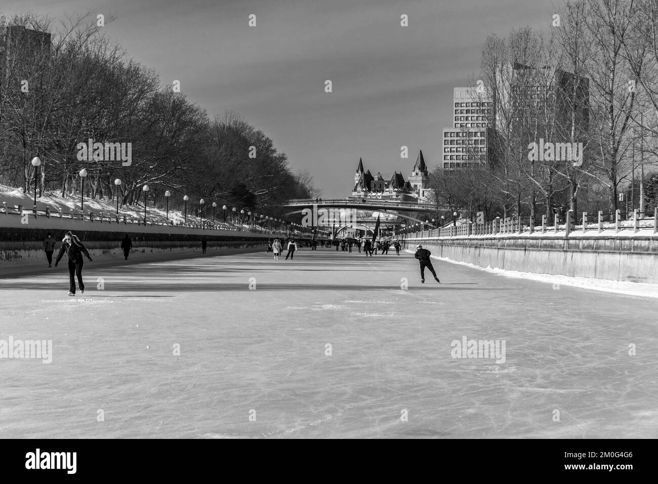 Ein Blick auf die Leute, die während Winterlude auf dem Rideau Canal mit der Skyline von Ottawa skaten Stockfoto