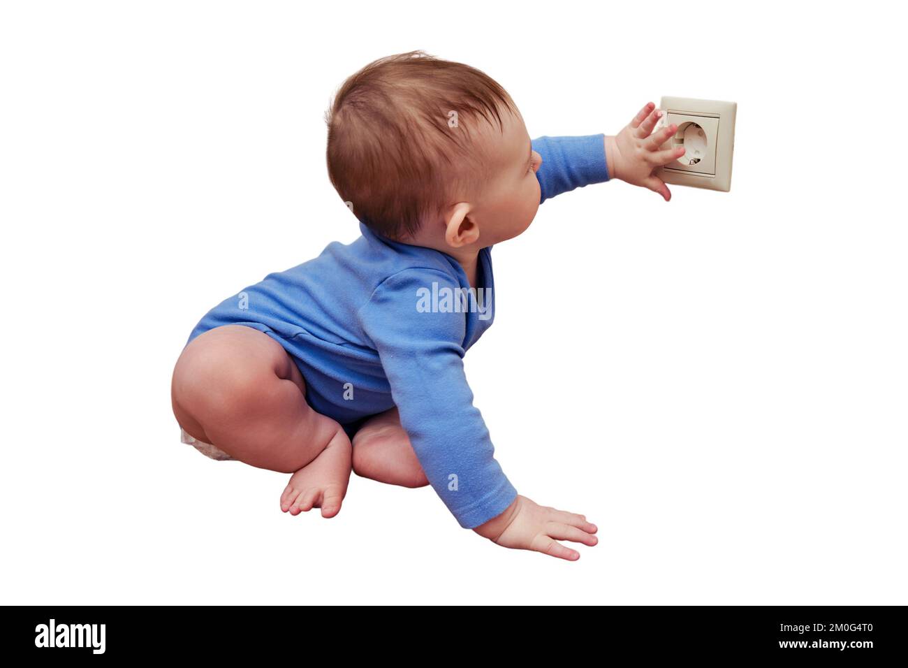 Das Baby greift mit seiner Hand in die Steckdose an der Wand, isoliert auf weißem Hintergrund. Gefahr und Schutz von Kinderfingern Stockfoto