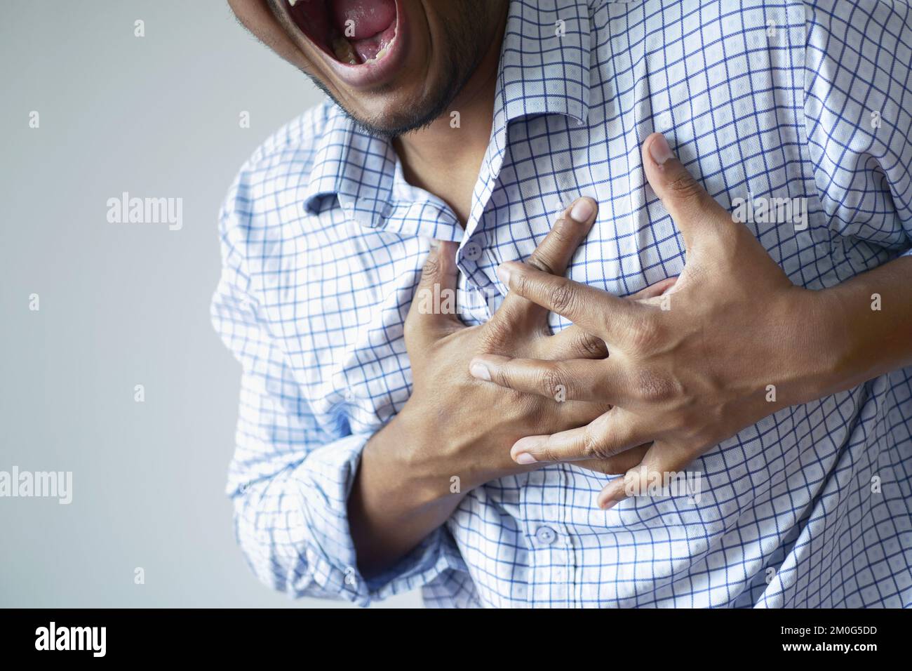 Junger Mann leidet Schmerzen im Herzen und hält Brust mit Hand Stockfoto