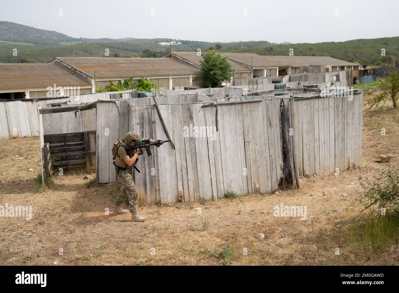 Airsoft-Spieler in offensiver taktischer Position geht auf Position. Der Sport, der deine taktischen Fähigkeiten auf die Probe stellt Stockfoto