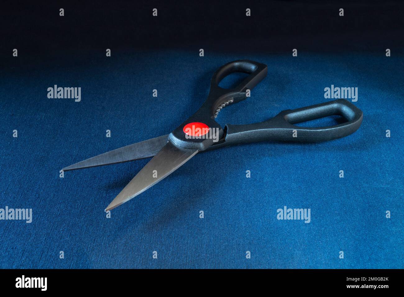 Schere mit Stahlklinge auf dem Tisch. Werkzeuge zum Schneiden von Gewebe auf schwarzem Hintergrund Stockfoto