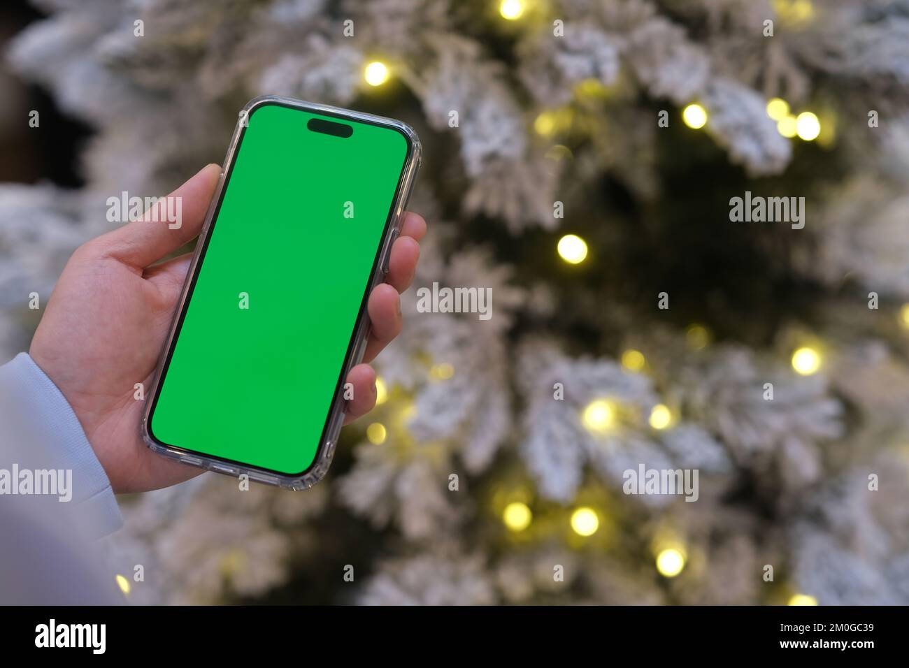 Smartphone mit grünem Bildschirm und Weihnachtsabend in der Nacht Stockfoto