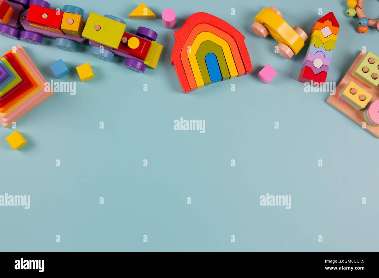 Hintergrund für Kinderspielzeug. Holzzug, farbenfrohes, nachhaltiges Lernspielzeug auf hellblauem Hintergrund. Montessori, umweltfreundliches Kinderspielzeug Stockfoto