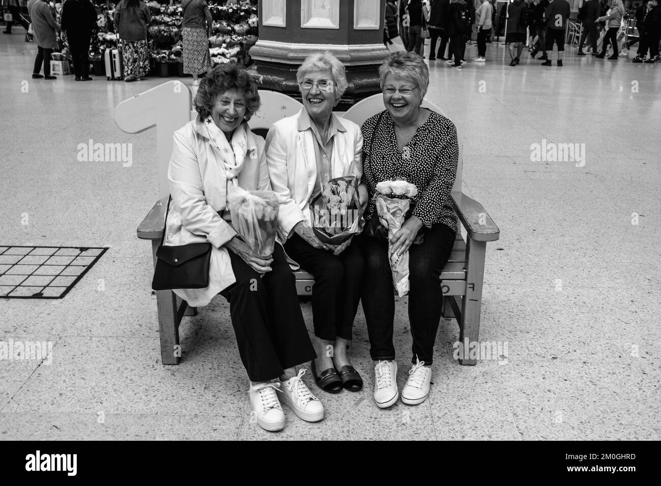 Eine Gruppe hochrangiger Frauen an der Victoria Station mit Blumenstraußen auf dem Weg zum Buckingham Palace nach dem Tod der Königin, London, Großbritannien. Stockfoto