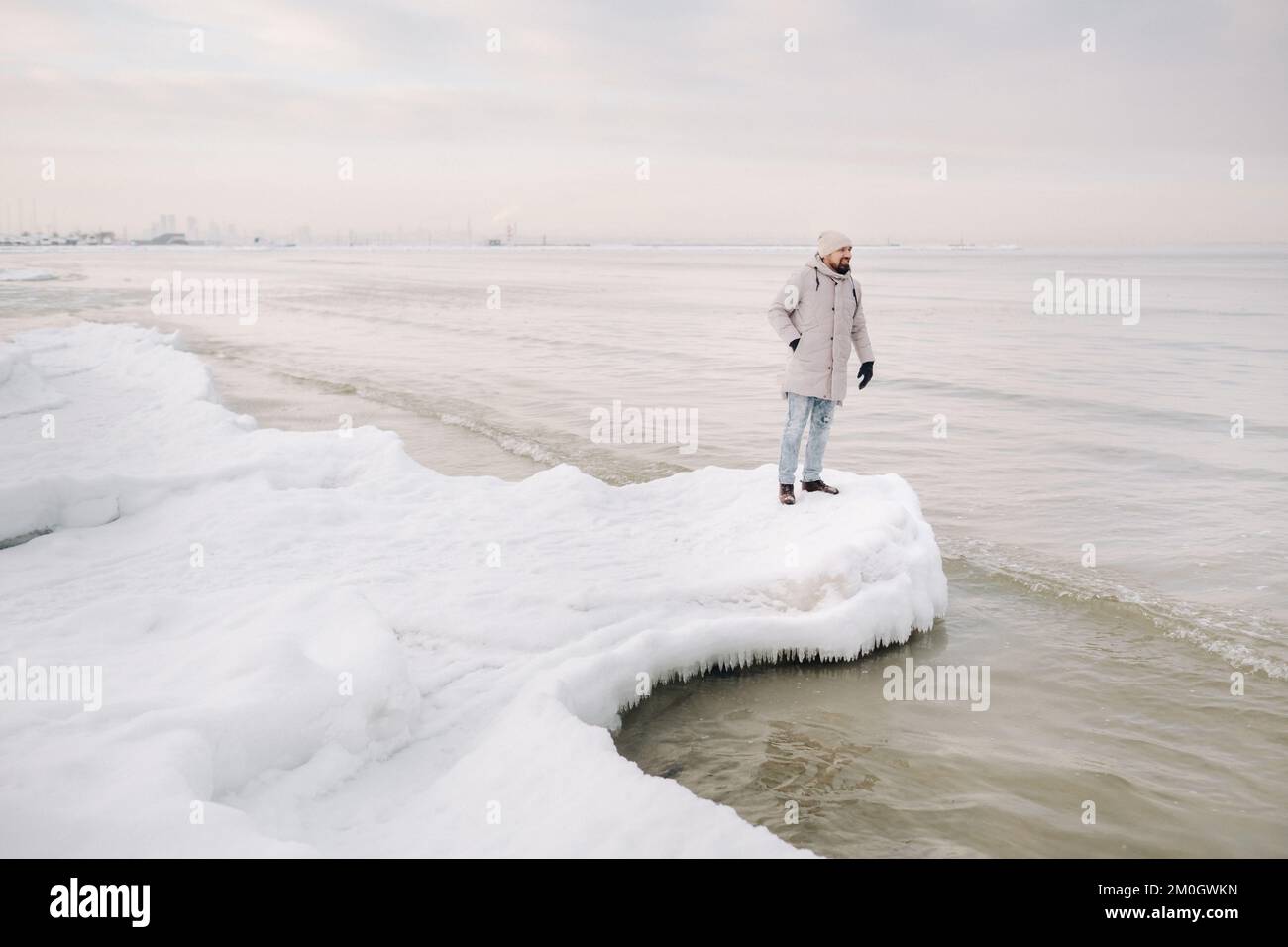 Im Winter steht ein Tourist am Ufer der Ostsee. Winter in der Nähe der baltischen Staaten von Tallinn.Reisende in der Nähe des Meeres im Winter Stockfoto