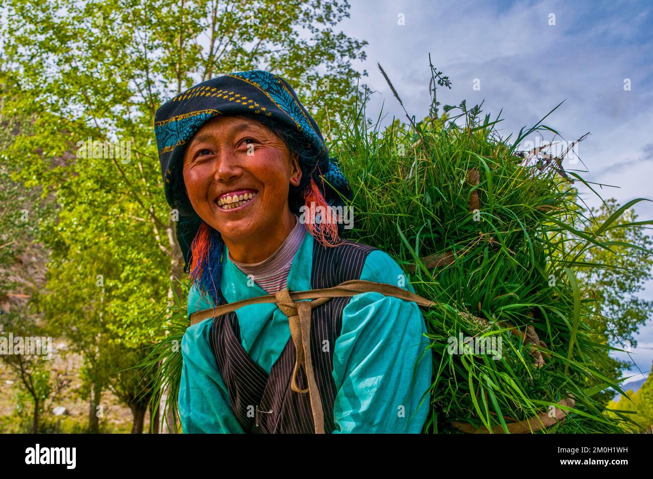 Freundliche Frau mit Heu auf dem Rücken, die vom Feld zurückkommt, Lhasa, Tibet, Asien Stockfoto Freundliche Frau mit Heu auf dem Rücken, die vom Feld zurückkommt, Lhasa, Tibet, Asien Stockfoto