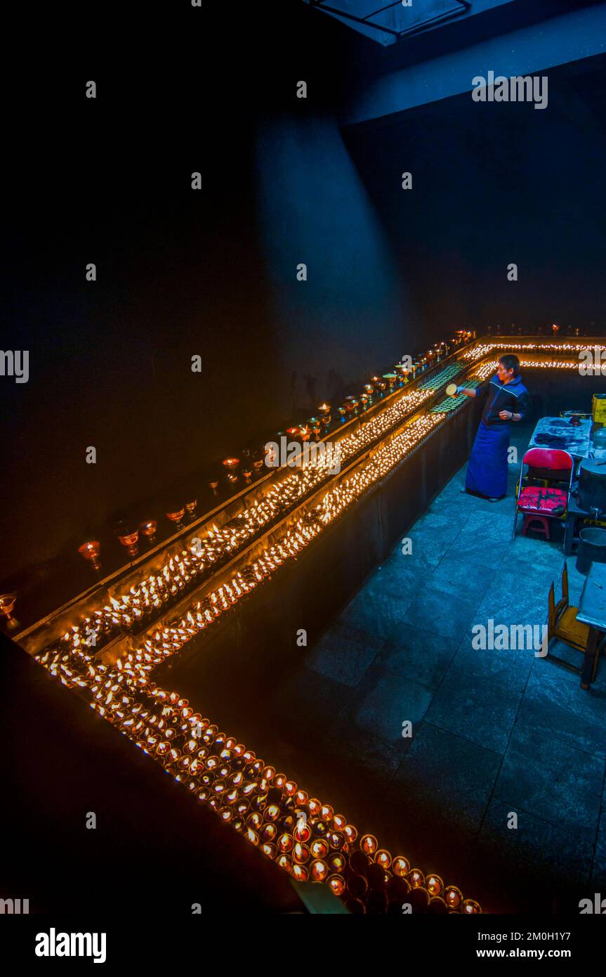 Dunkler Raum mit vielen Kerzen im Ramoche-Tempel, Lhasa, Tibet, Asien Stockfoto