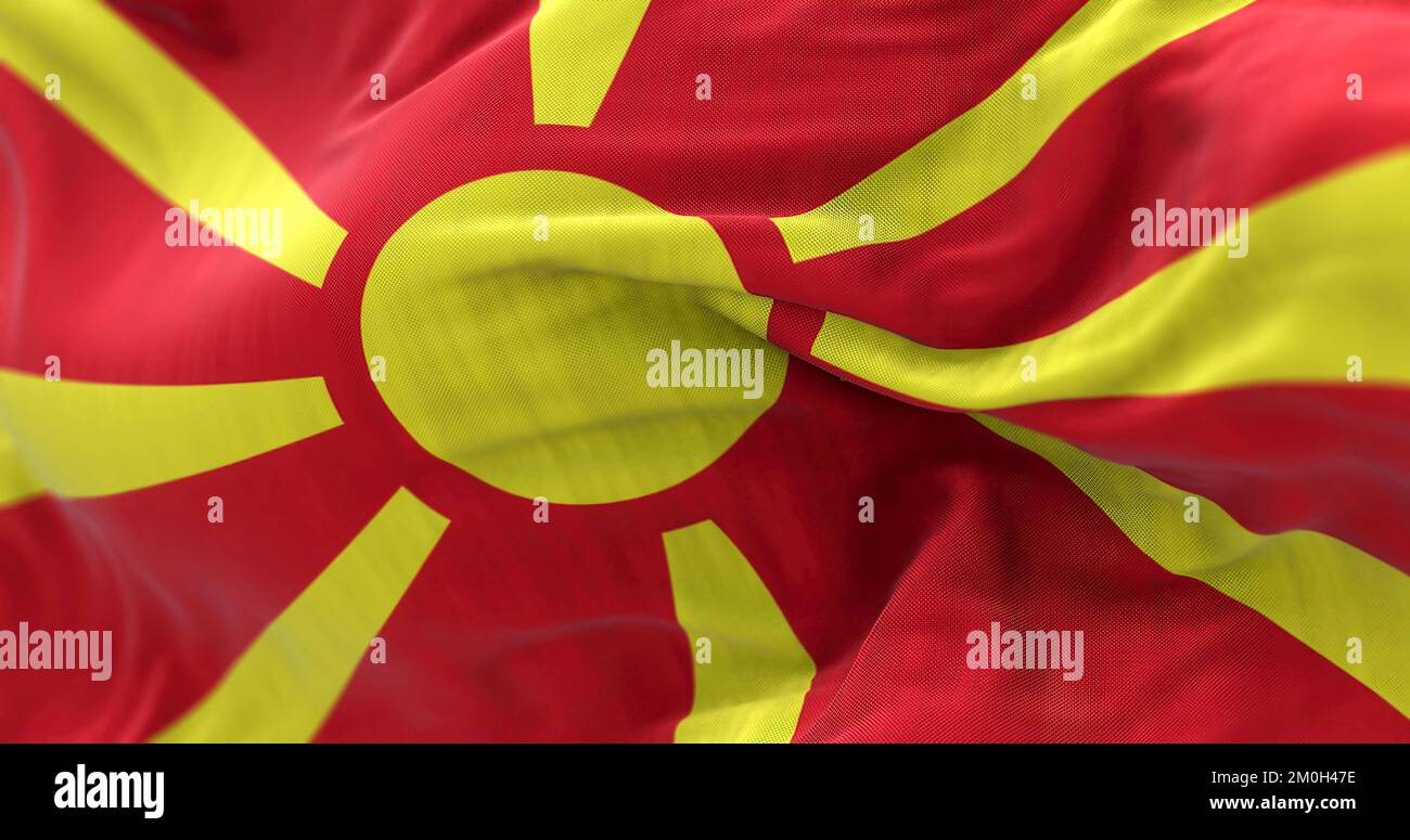 Nahaufnahme der Nationalflagge Nordmazedoniens, die im Wind winkt. Die Republik Nordmakedonien ist ein Land in Südosteuropa. Texturierter Stoff b Stockfoto