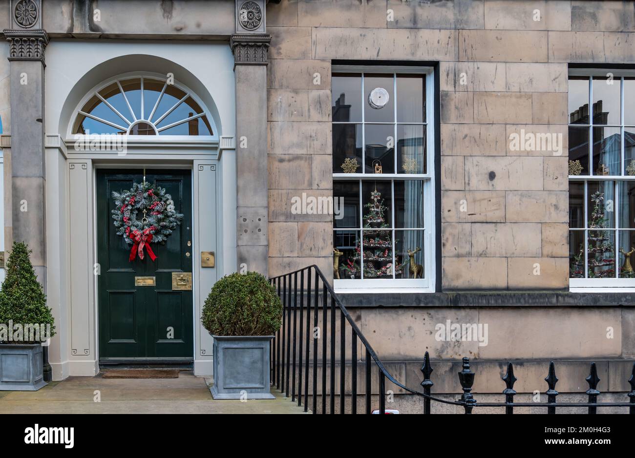 Edinburgh New Town, Schottland, Großbritannien, 6.. Dezember 2022. Kränze und Dekorationen der Weihnachtstüren: Die Bewohner der georgianischen Stadthäuser in der Neustadt sind bekannt für ihre prächtigen Dekorationen. Ein Weihnachtskranz an einer Haustür und ein Weihnachtsbaum im Fenster. Kredit: Sally Anderson/Alamy Live News Stockfoto