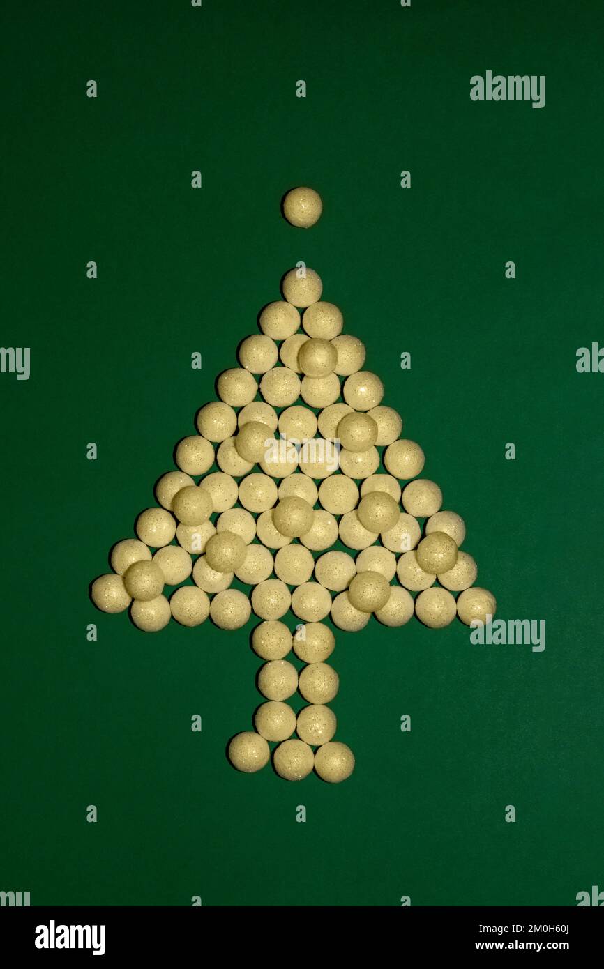 Weihnachtsbaum aus goldenen Globen auf grünem Hintergrund Stockfoto
