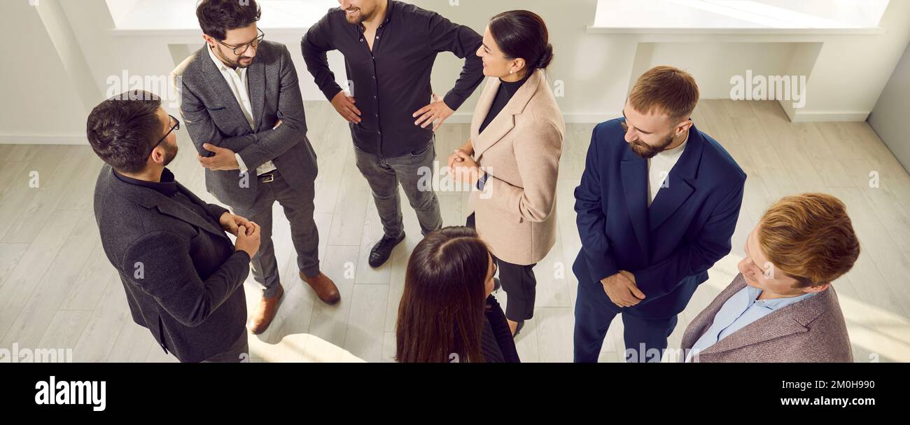 Gruppe positiver Geschäftsleute im Büro, die ein entspanntes Gespräch über ein neues Projekt führen. Stockfoto