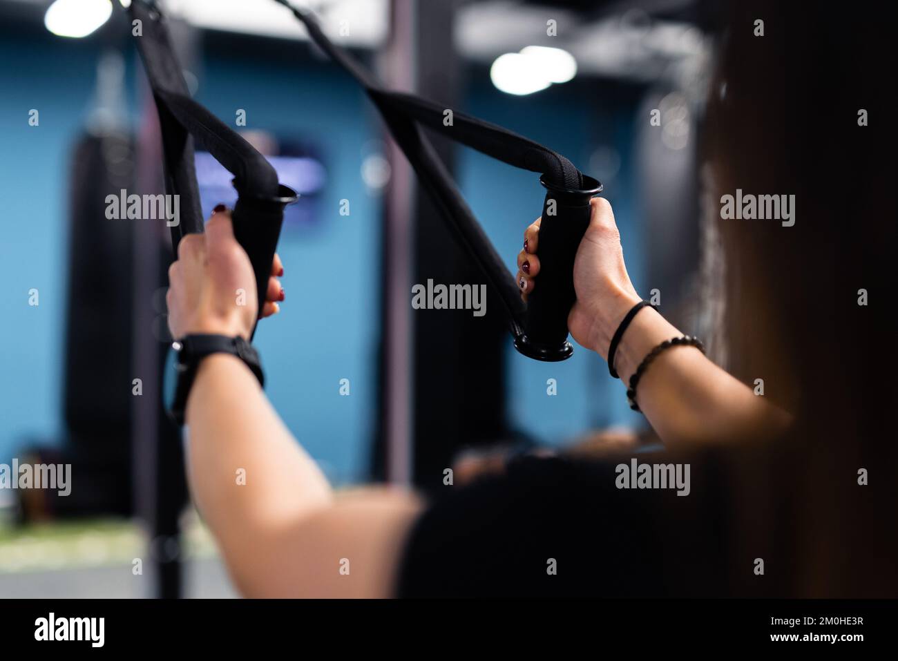 Gesichtsloses Modell mit langen Haaren, das im Fitnessstudio trainiert Stockfoto