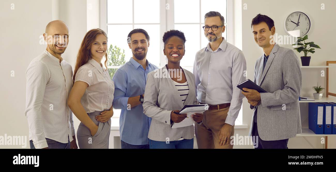 Ein Team erfolgreicher, lächelnder Geschäftsleute aus verschiedenen Rassen, die im Büro stehen Stockfoto