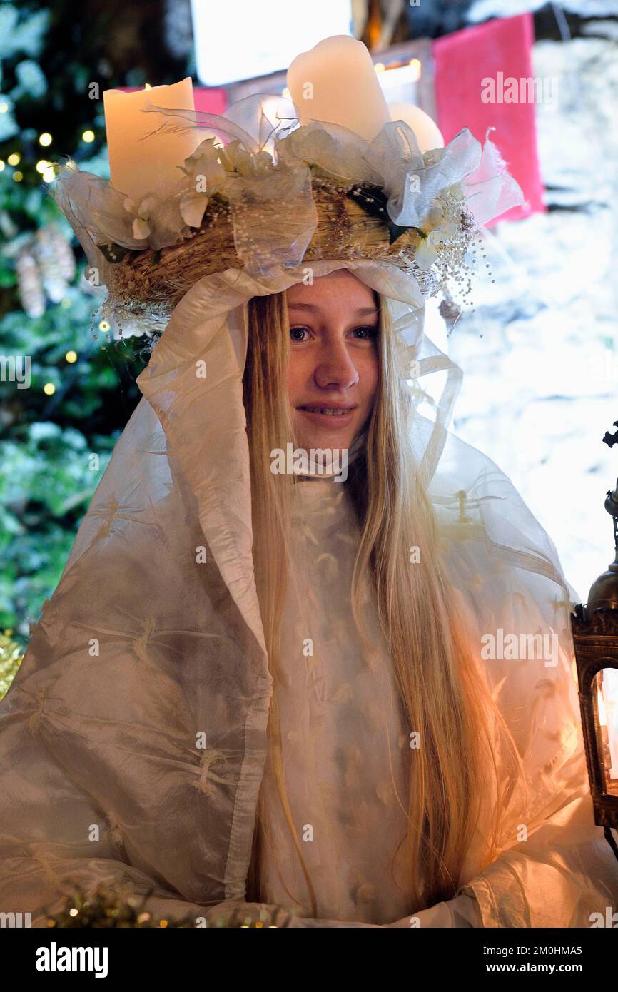 Frankreich, Haut Rhin, Eguisheim, der Christkindel mit seiner Krone aus Kerzen und die Engel begleiten die vielen Kinder, die ihre Laternen für die Lichterprozession in den Gassen der Stadt halten, sie ehrt die Heilige Lucia, eine der traditionellen Charaktere der elsässischen Weihnachten Stockfoto