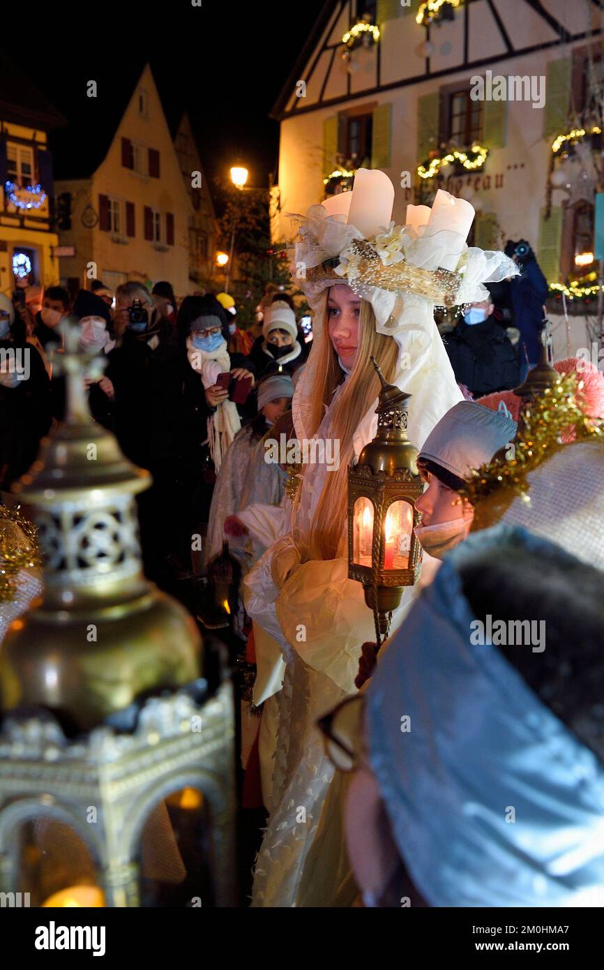 Frankreich, Haut Rhin, Eguisheim, der Christkindel mit seiner Krone aus Kerzen und die Engel begleiten die vielen Kinder, die ihre Laternen für die Lichterprozession in den Gassen der Stadt halten, sie ehrt die Heilige Lucia, eine der traditionellen Charaktere der elsässischen Weihnachten Stockfoto