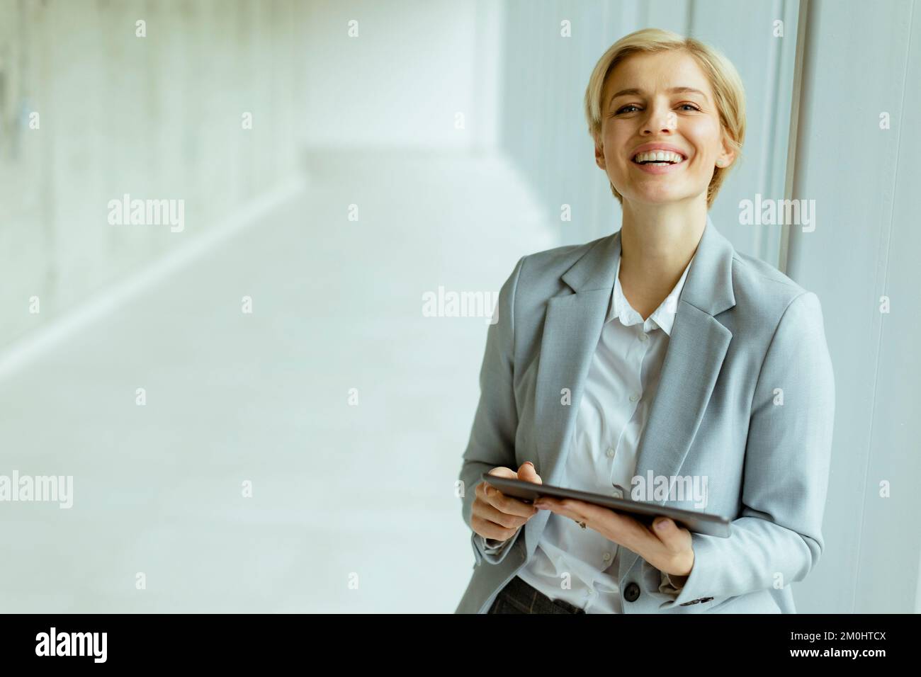Hübsche Geschäftsfrau mit digitalem Tablet im Büroflur Stockfoto