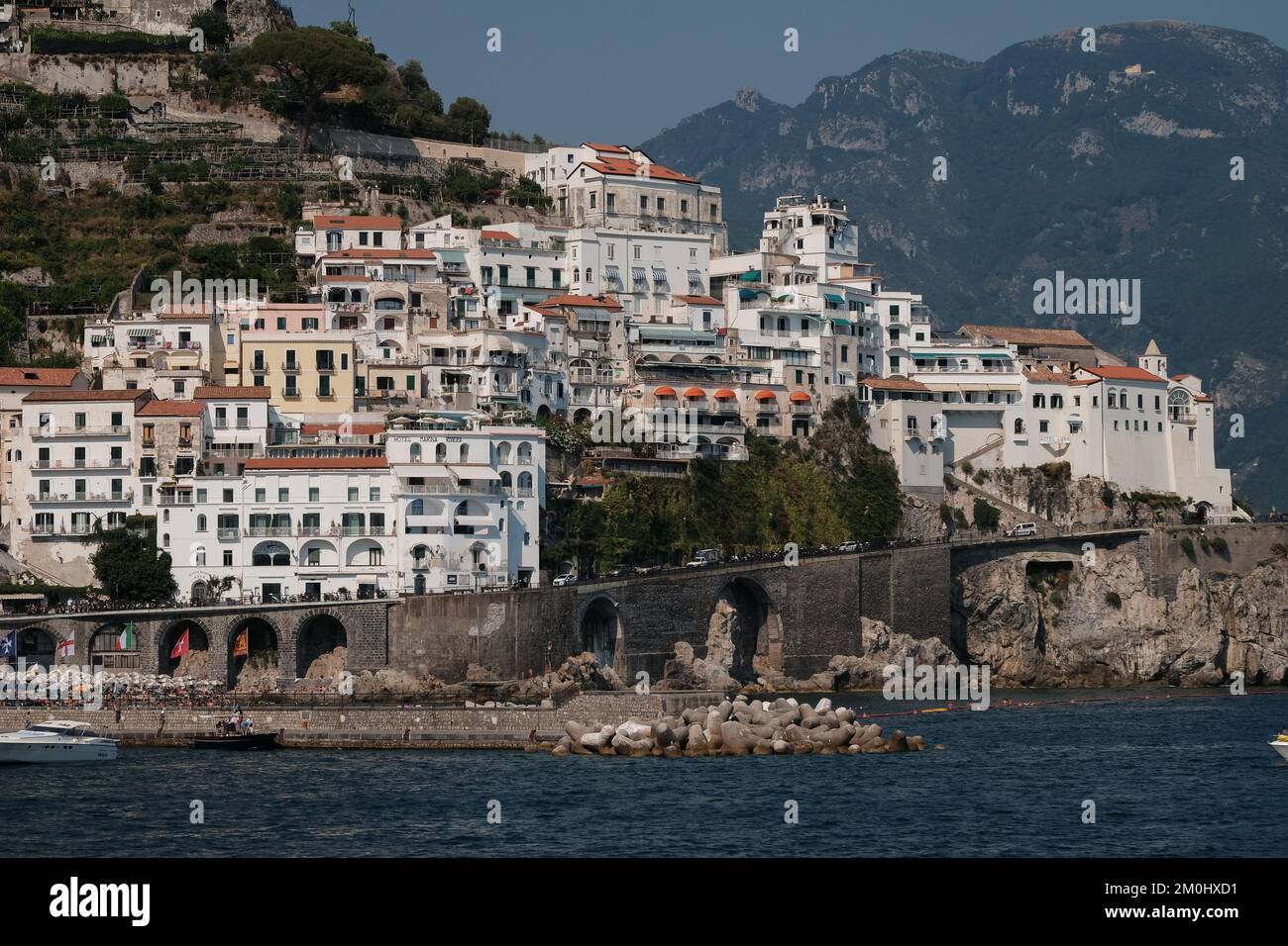 Ein Blick auf Amalfi Stadt in Richtung Osten mit den Anwesen auf den aufsteigenden Klippen mit Meer und Hafen im Vordergrund. Stockfoto