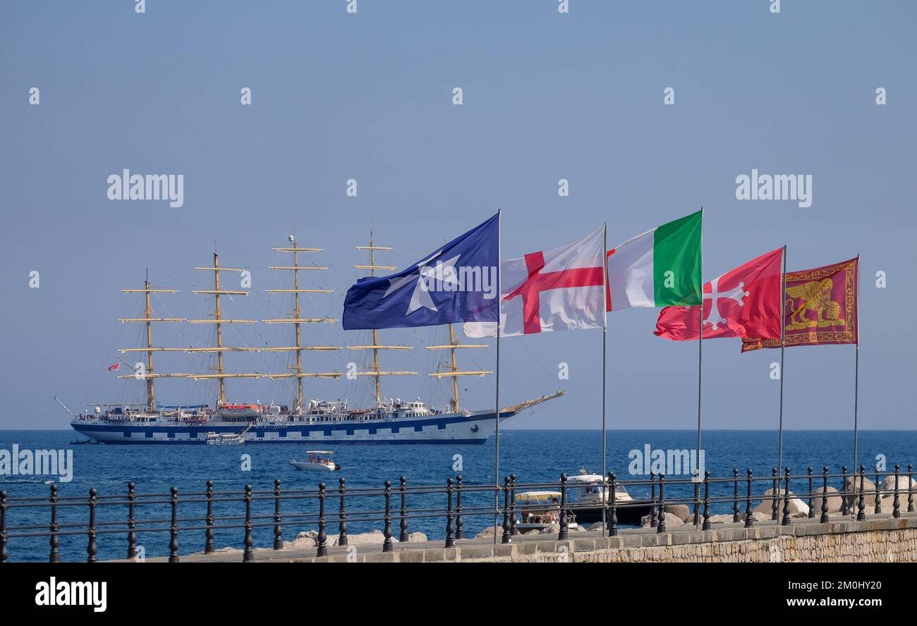 Das Royal Clipper Großsegler sah vor dem Hafen von Amalfi Italien. Mit den Flaggen der maritimen Republiken im Vordergrund. Stockfoto