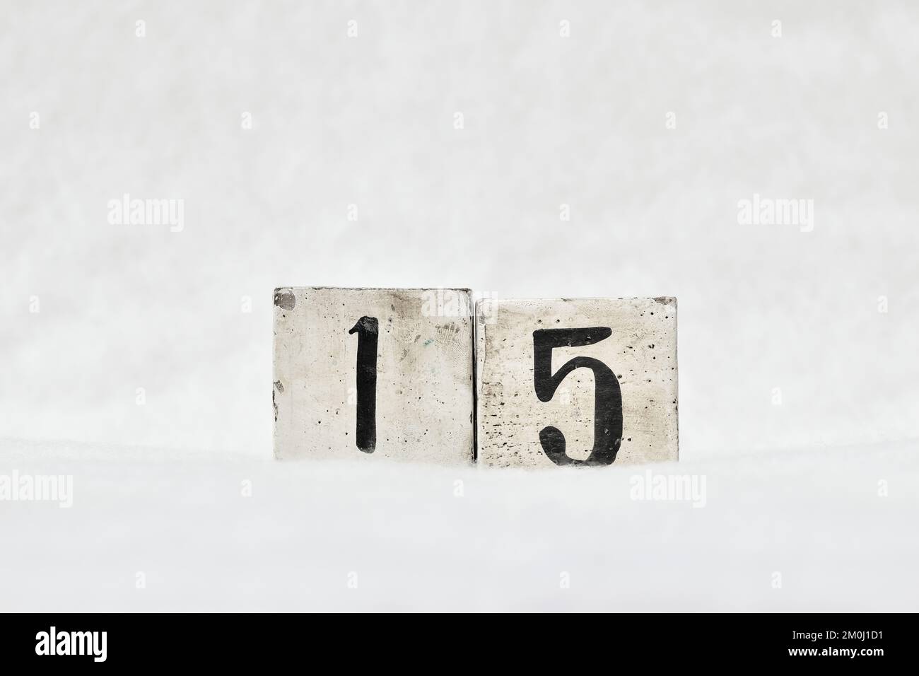15 Kalendernummer aus altem Holzblock auf weißem Schneehintergrund, Kopierbereich für Text. Merken Sie sich das Datum für Geburtstag, Jubiläum, besonderen Tag oder Anlass Stockfoto