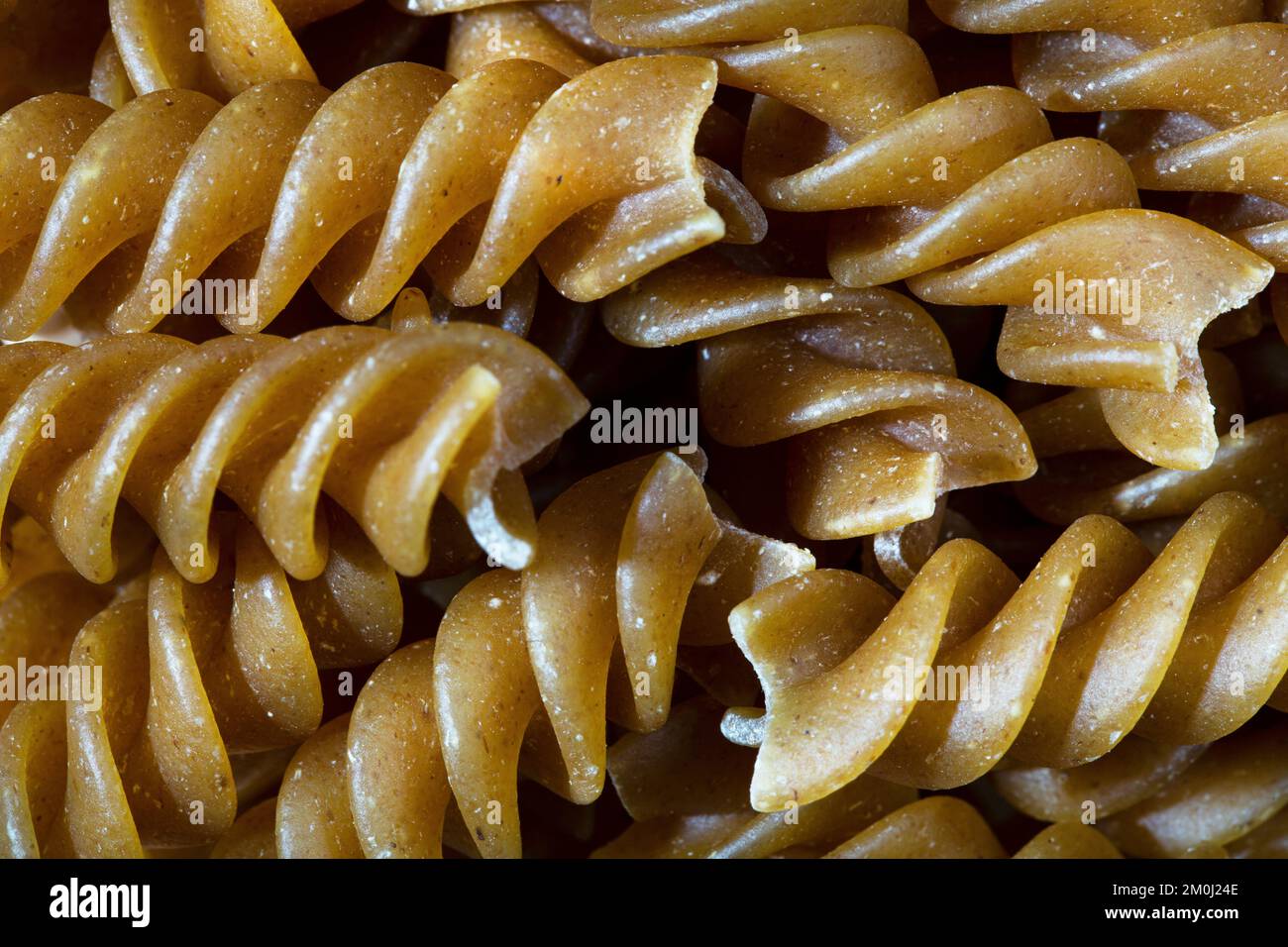 Die Konsistenz roher Fusilli-Nudeln als Hintergrund. Ein Nahschuss Nudeln. Makrofoto.Raw Fusilli Pasta. Stockfoto