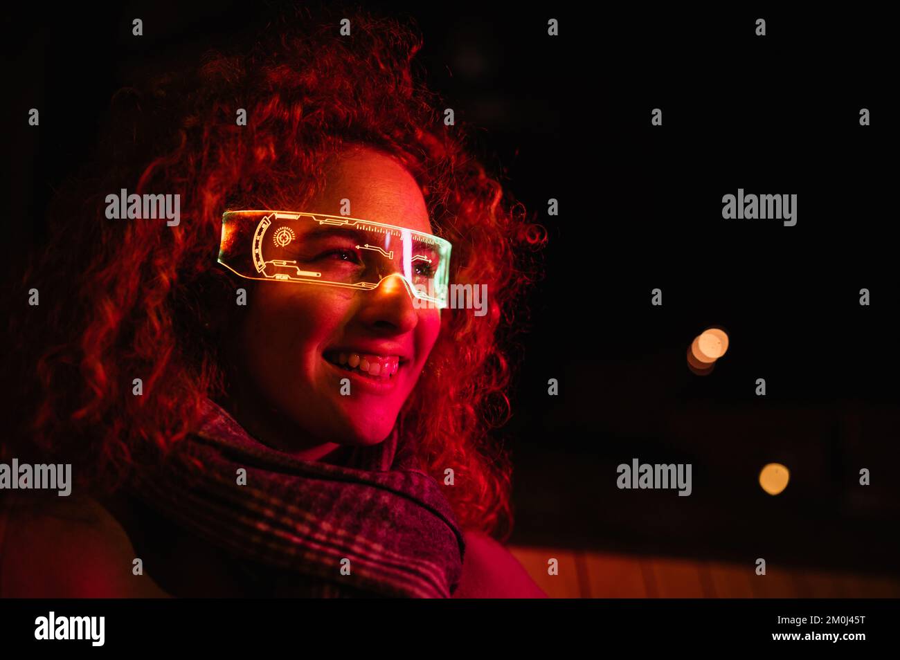 Lächelnde Frau mit glühender, intelligenter Brille auf der Straße. Stockfoto