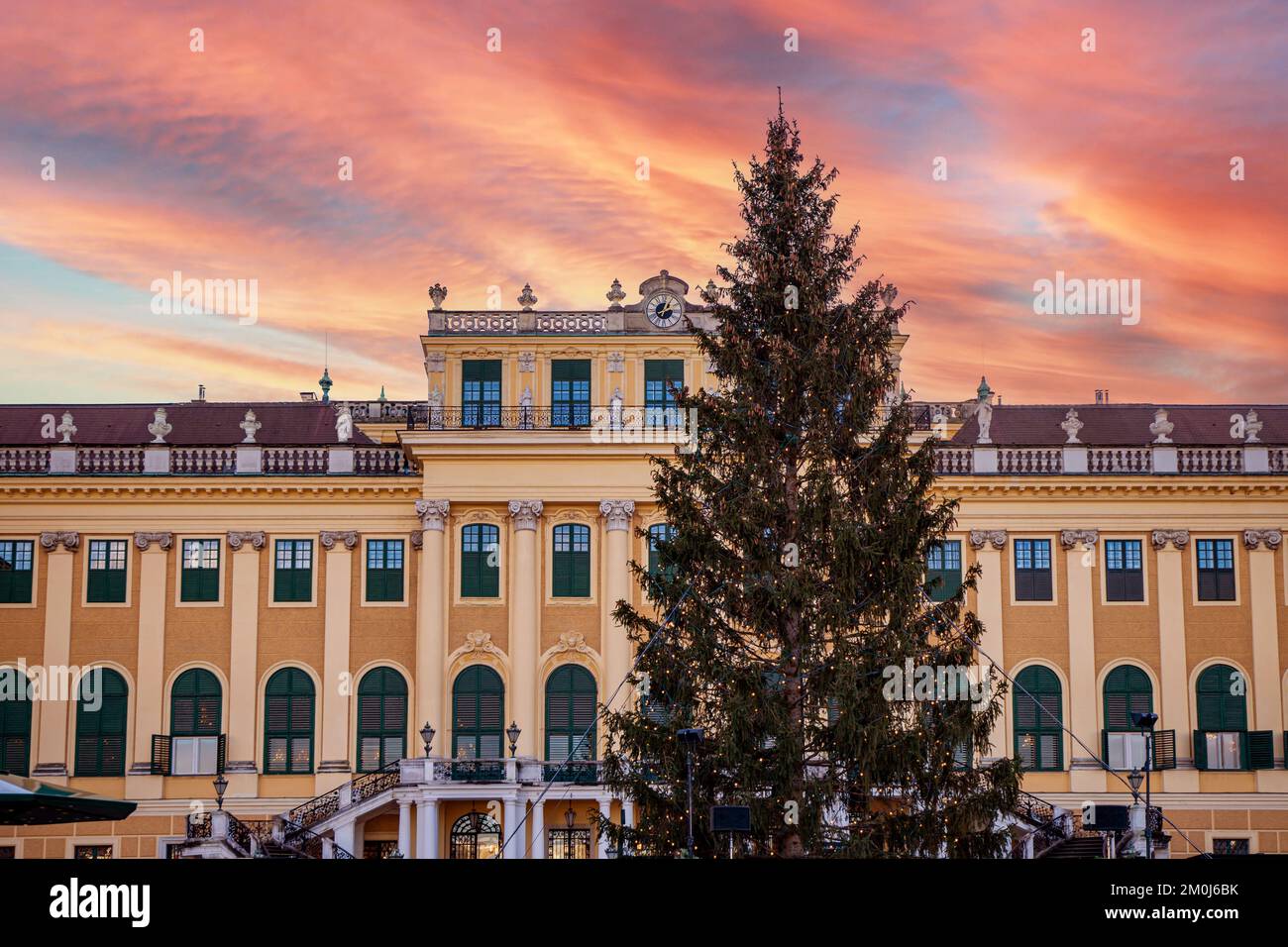 Schloss Schönbrunn und sein Weihnachtsbaum bei Sonnenuntergang. Traditionelles Panorama des Weihnachtsmarkts auf der Burg Sissi in Wien. Stockfoto
