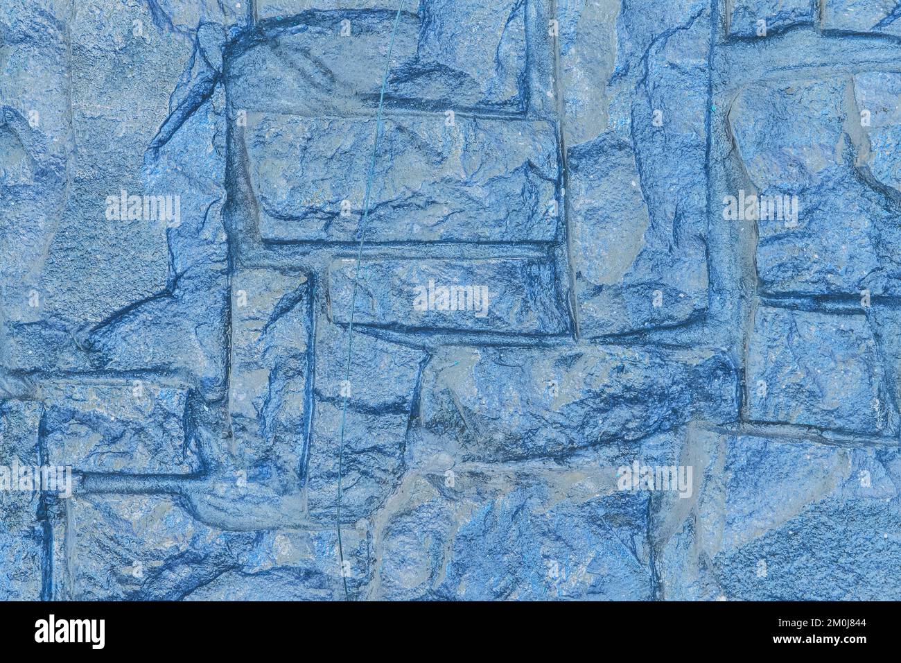 Steinblaue moderne Wand mit abstraktem Muster auf dem Hintergrund der Oberflächengesteinstruktur. Stockfoto