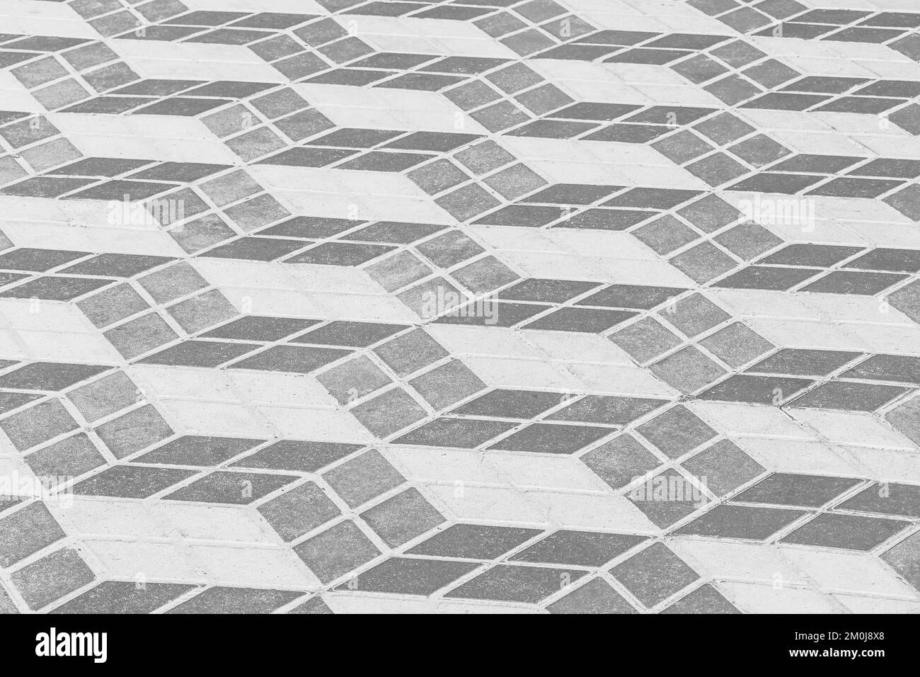 Dunkle und helle Fliesen mit abstraktem geometrischem Quadratmuster für die Pflastertextur Straßenkultur im urbanen Hintergrund. Stockfoto