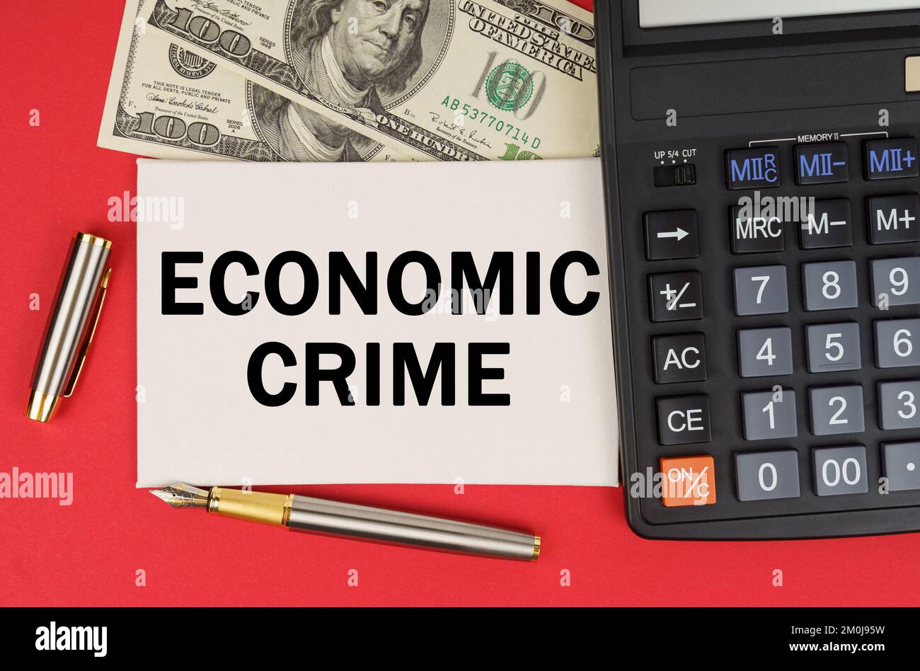 Geschäfts- und Finanzkonzept. Auf rotem Hintergrund, unter dem Geld, liegt ein Taschenrechner und ein Stift ein Schild mit dem Text WIRTSCHAFTSKRIMINALITÄT Stockfoto