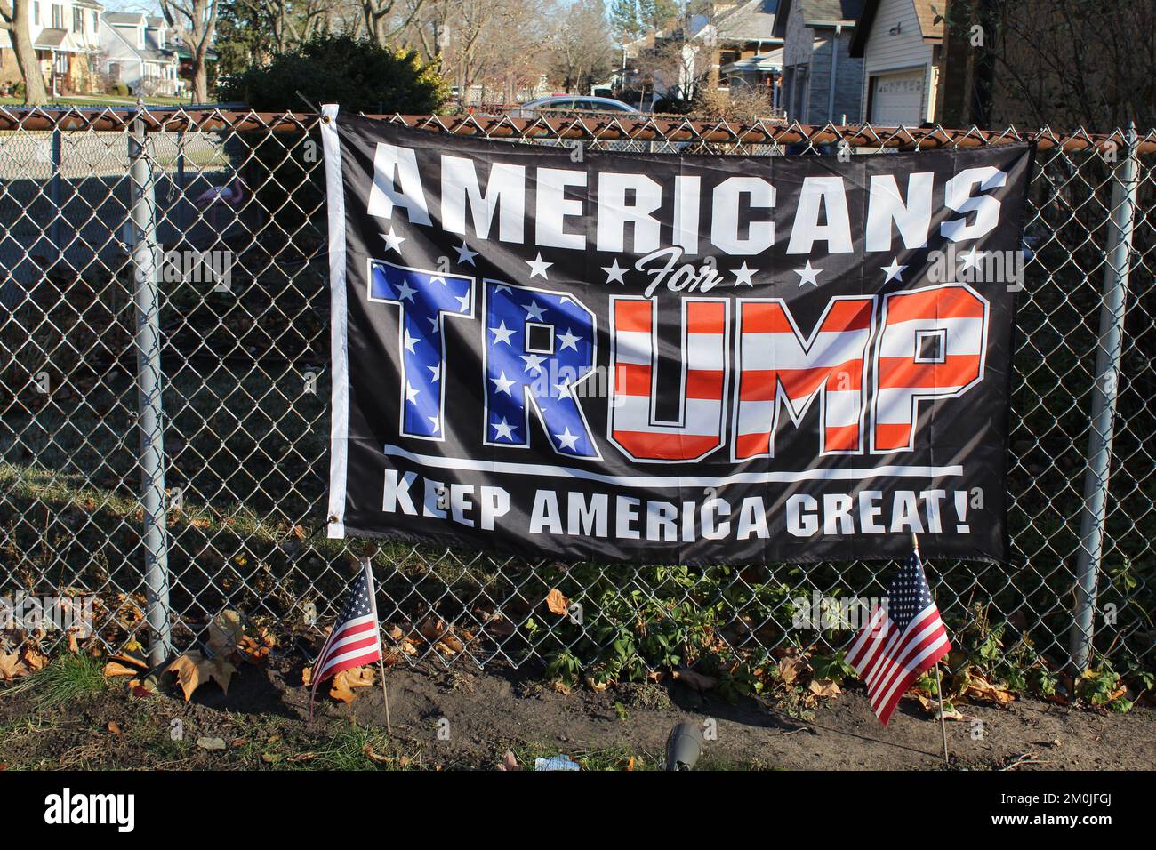 Nahaufnahme einer US-Flagge für Trumpf auf einem Zaun mit zwei kleinen US-Flaggen davor in des Plaines, Illinois Stockfoto