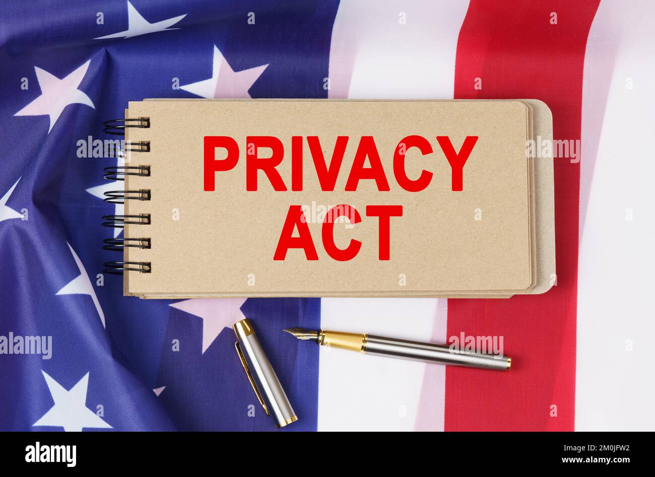 Recht und Ordnung. Vor dem Hintergrund der Flagge der Vereinigten Staaten von Amerika liegt ein Notizbuch mit der Aufschrift "PRIVACY ACT" Stockfoto
