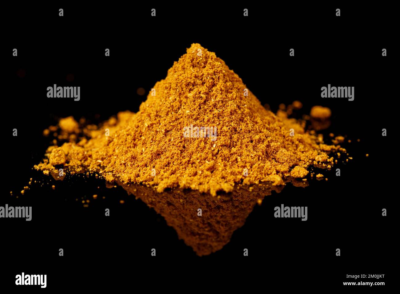 Ein Haufen Currypulver auf schwarzer, reflektierender Oberfläche, indisches Grundnahrungsmittel Stockfoto Ein Haufen Currypulver auf schwarzer, reflektierender Oberfläche, indisches Grundnahrungsmittel Stockfoto