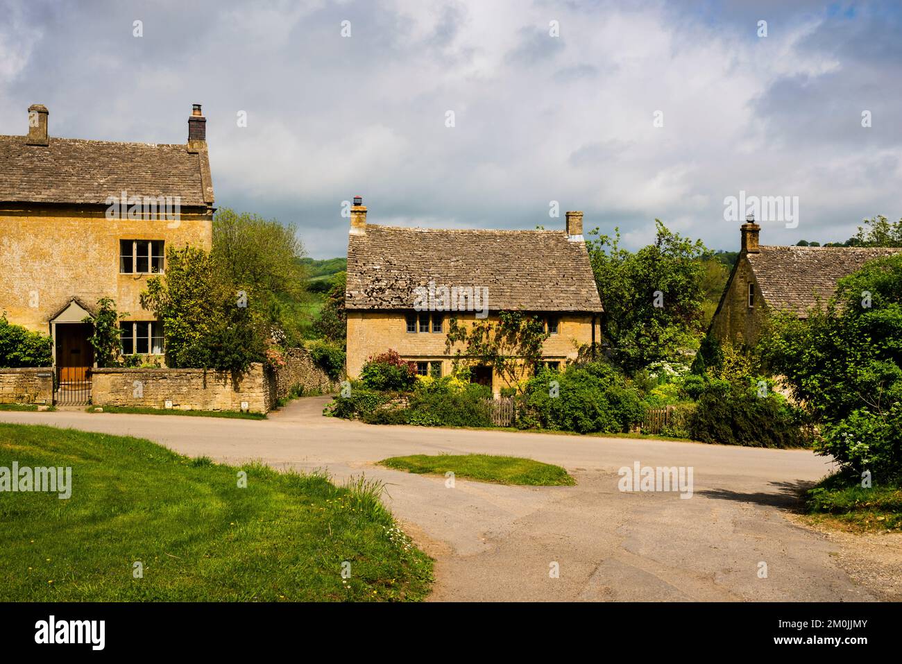 Cottages mit Pfosten und Schiefersteinfeldächern in Guiting Power, Cotswolds District, England. Stockfoto