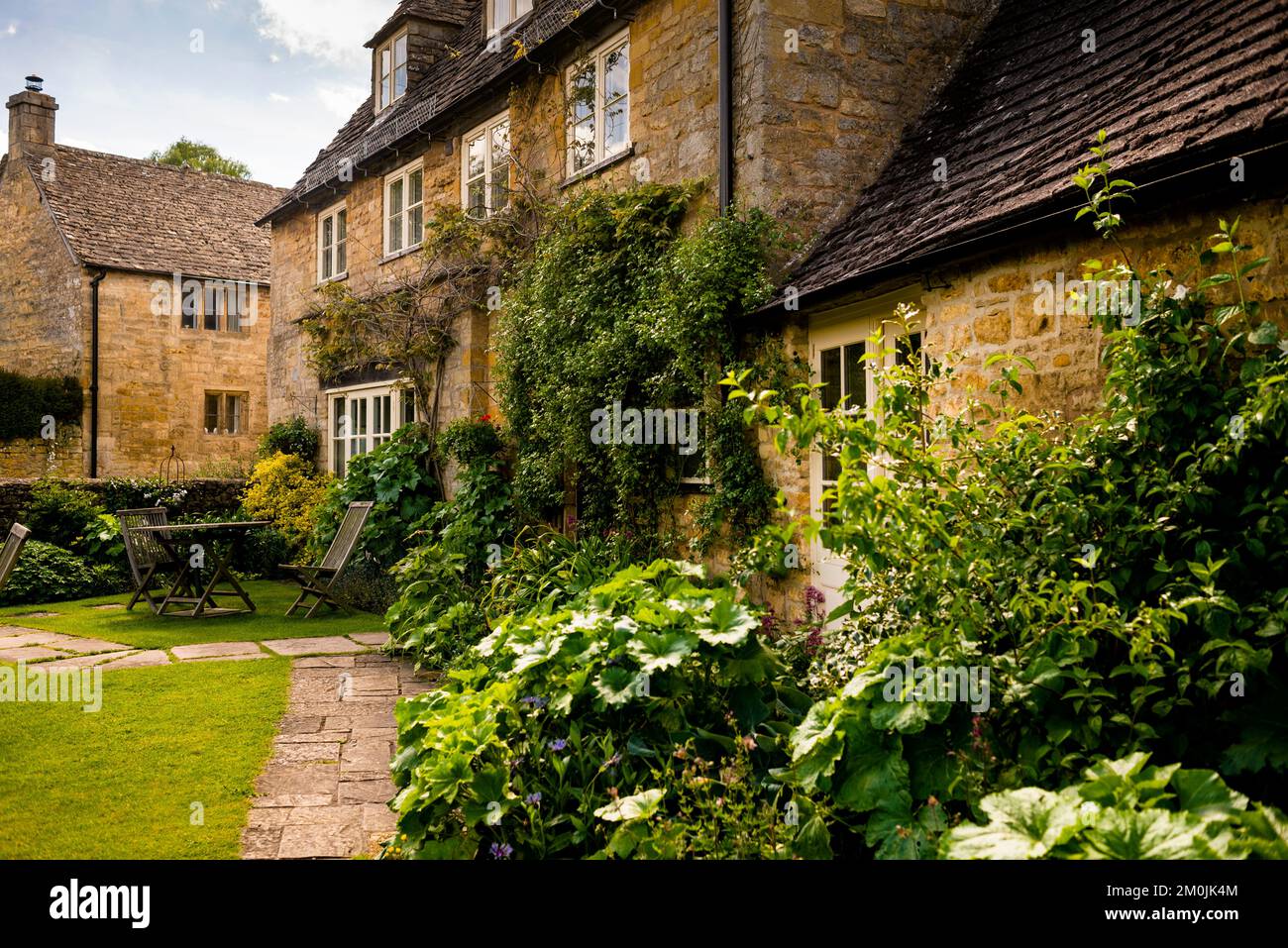 Englische Schieferdächer, Doppelfenster und winzige Dachbalken im Dorf Guiting Power im Cotswold District. Stockfoto