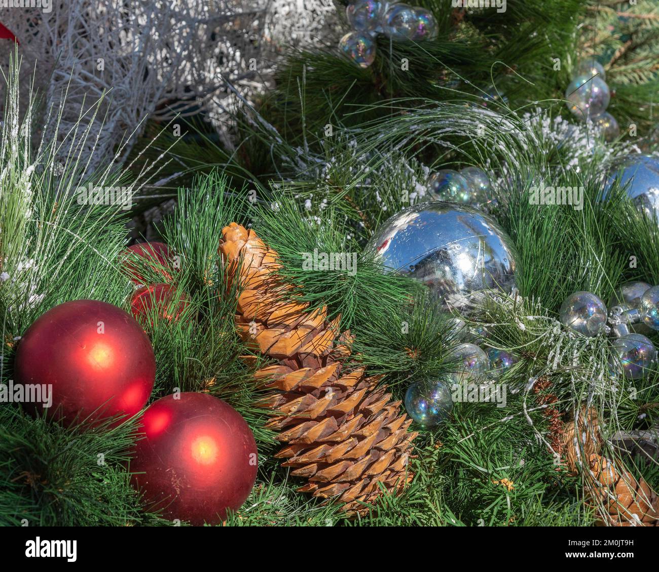 Nahaufnahme eines dekorierten Weihnachtsbaums mit silbernen und roten Kugeln. Stockfoto