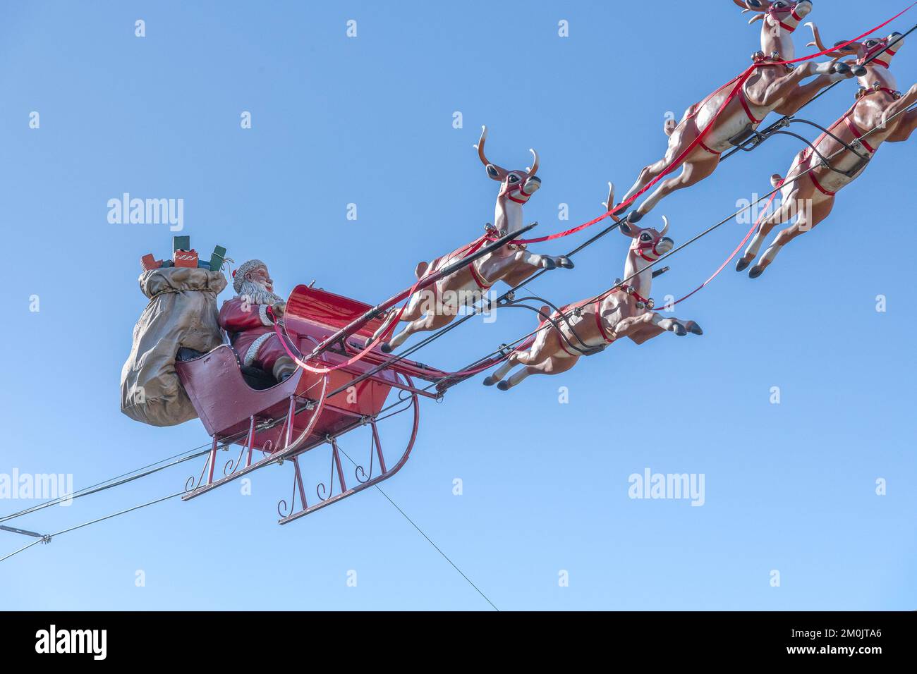 Los Angeles, Kalifornien, USA – 5. Dezember 2022: Der Weihnachtsmann und sein Rentier fliegen in einem Einkaufszentrum in Los Angeles, Kalifornien, durch den blauen Himmel. Stockfoto