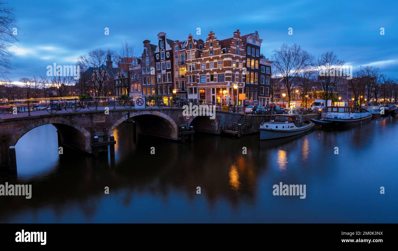 Amsterdam Niederlande Kanäle mit Weihnachtslichtern im Dezember, Grachtenhistorisches Zentrum von Amsterdam bei Nacht. Stockfoto