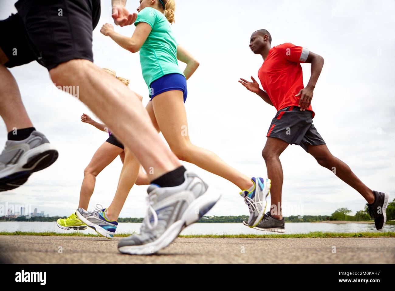 Bewegung und Bewegung. Niedrige Seitenansicht von Sportlern, die ein Rennen laufen. Stockfoto