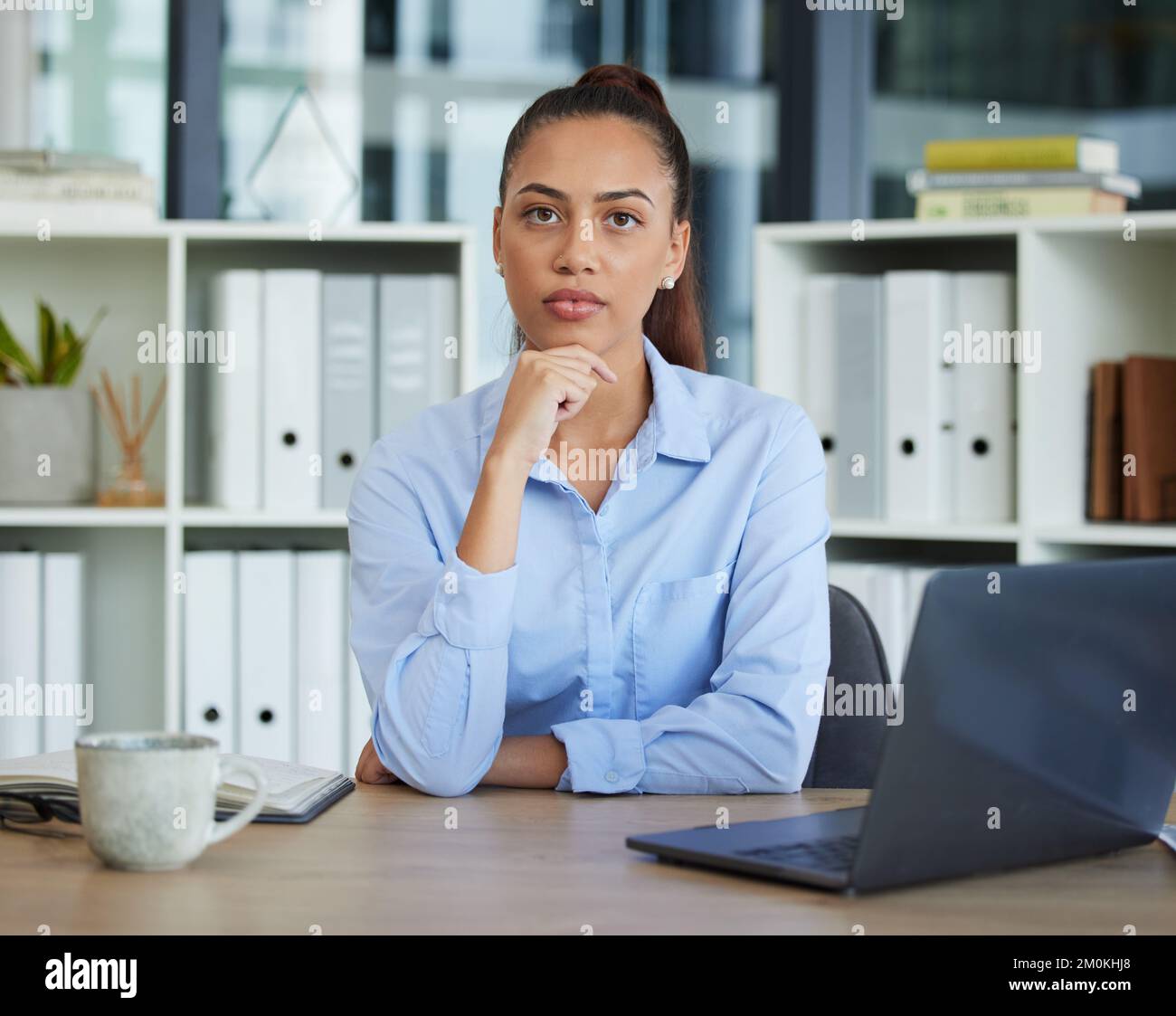 Geschäftsfrau, Denkerin und Laptop in Planung, Strategie oder Design, die am Schreibtisch im Büro sitzt. Weibliche Mitarbeiterin, die denkt, Ideen hat oder Stockfoto