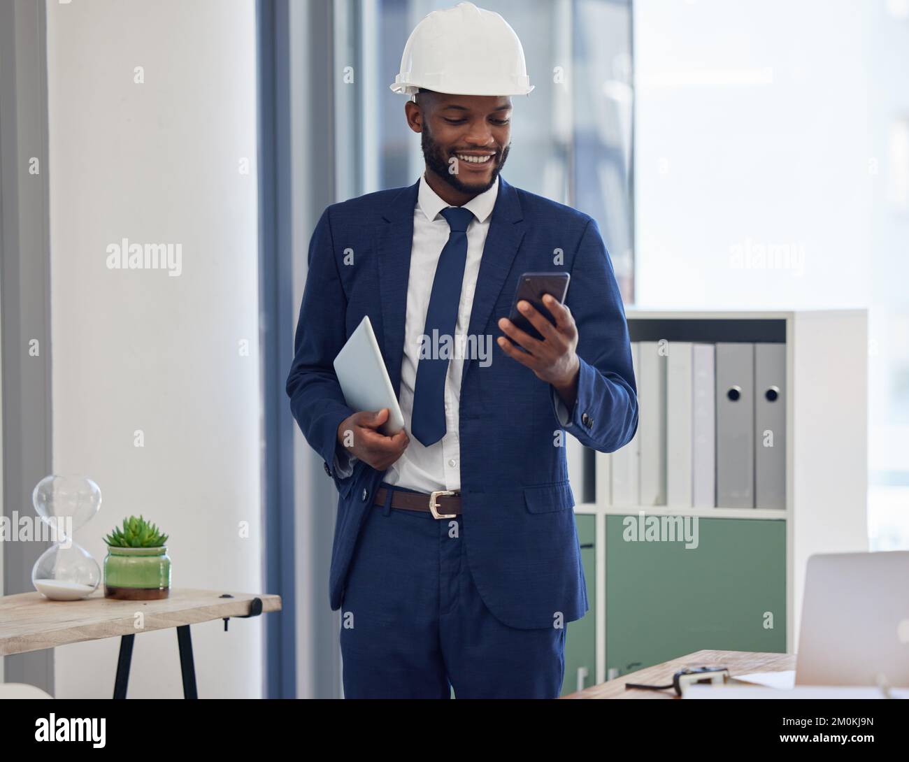 Architekt, Architektur und Schwarzer mit Smartphone im Büro, sehen Sie in sozialen Medien oder E-Mails nach, mit der Arbeitskommunikation und Technologie im Gebäude Stockfoto