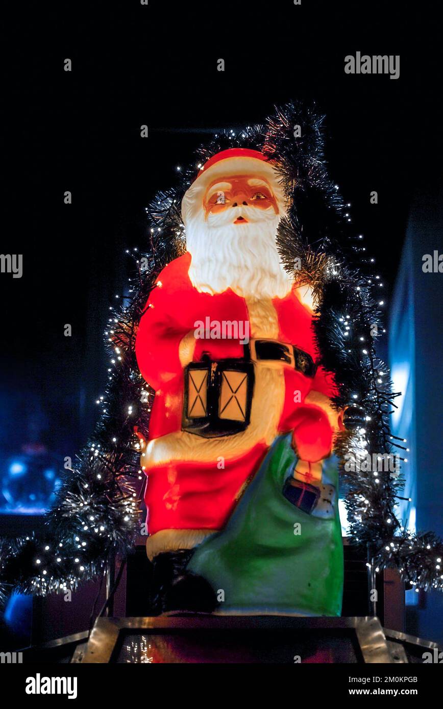 Beleuchtete Weihnachtsmann-Figur auf der Münchner Weihnachtsmesse bei Nacht mit dunklem Hintergrund Stockfoto