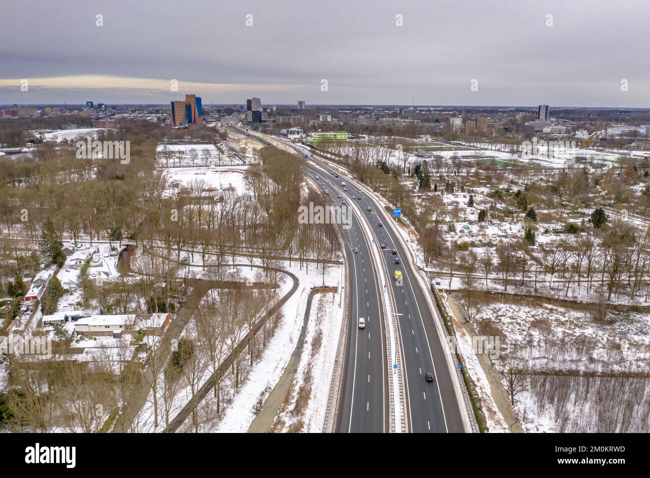 Werfen Sie einen Blick auf die Autobahn A7 mit der Stadt Groningen im Hintergrund bei Schnee und Winter. Stockfoto